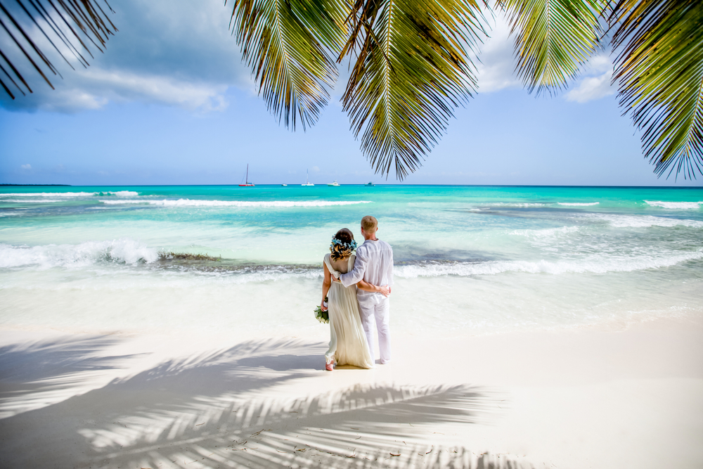 Newlyweds,Holding,Hands,Hugging,At,White,Sandy,Tropical,Caribbean,Beach